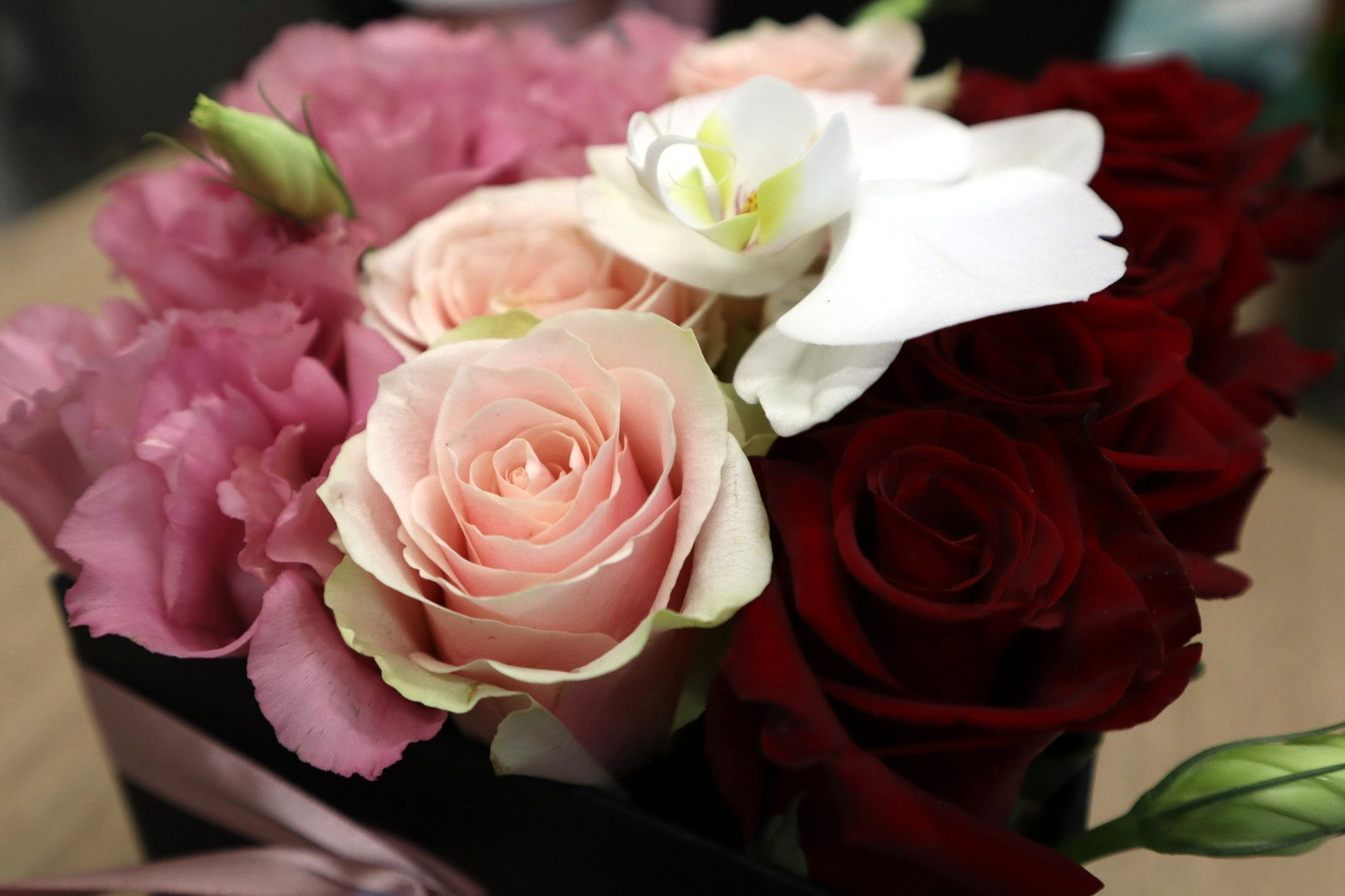 caja de rosas con lisianthus y orquidea