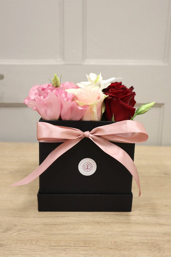 caja de rosas con lisianthus y orquidea