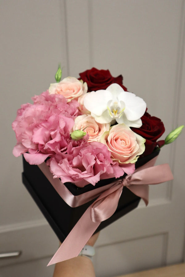 caja de rosas con lisianthus y orquidea